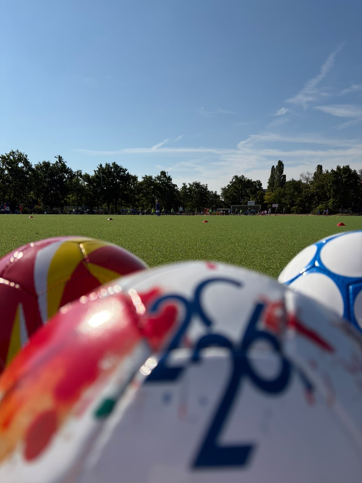 Mehrere Fußbälle liegen am Rand des Spielfeldes beim Turnier der dritten Klassen
