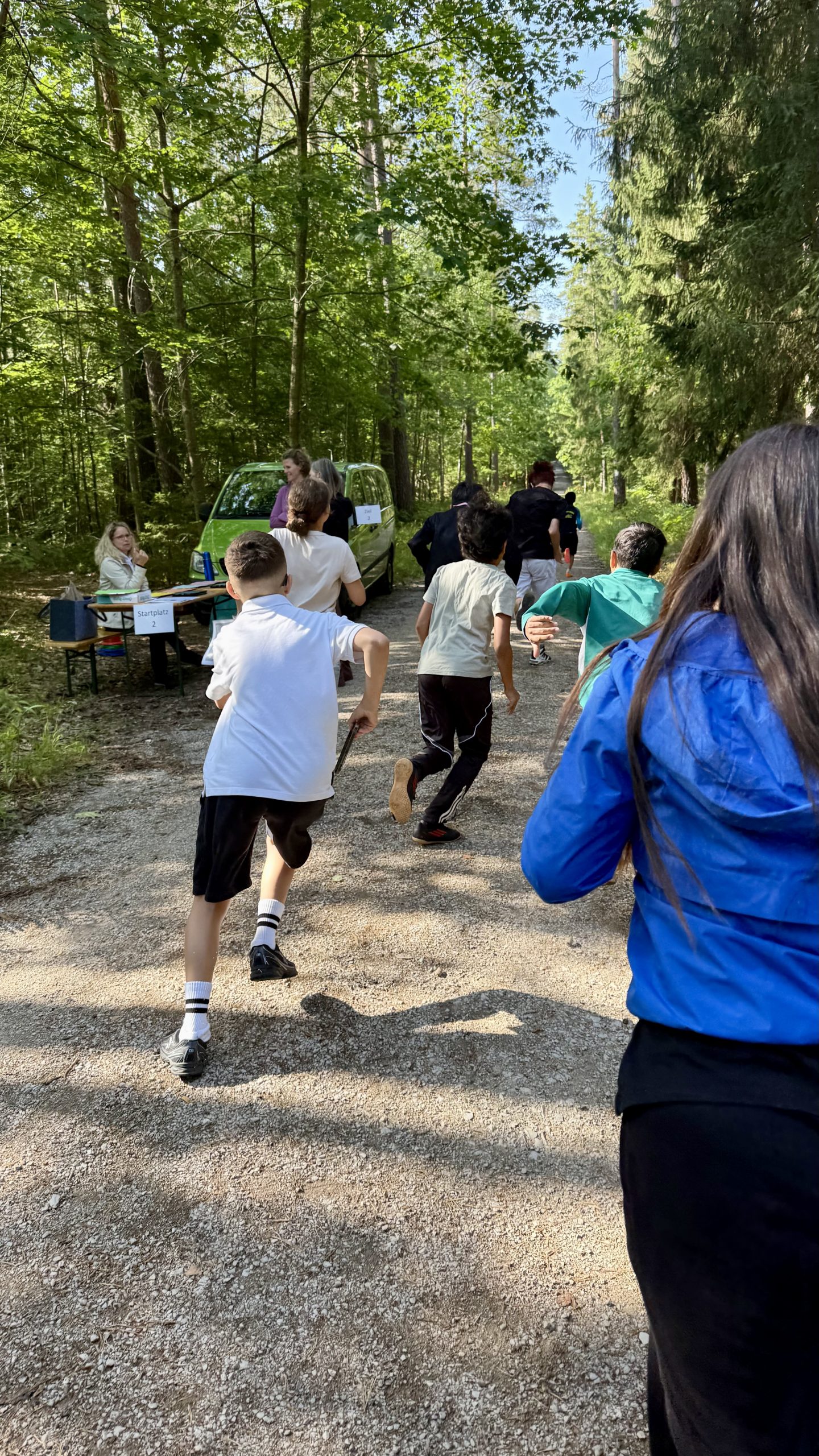 Schülerinnen und Schüler starten von hinten fotografiert in die Reichswald-Rallye.