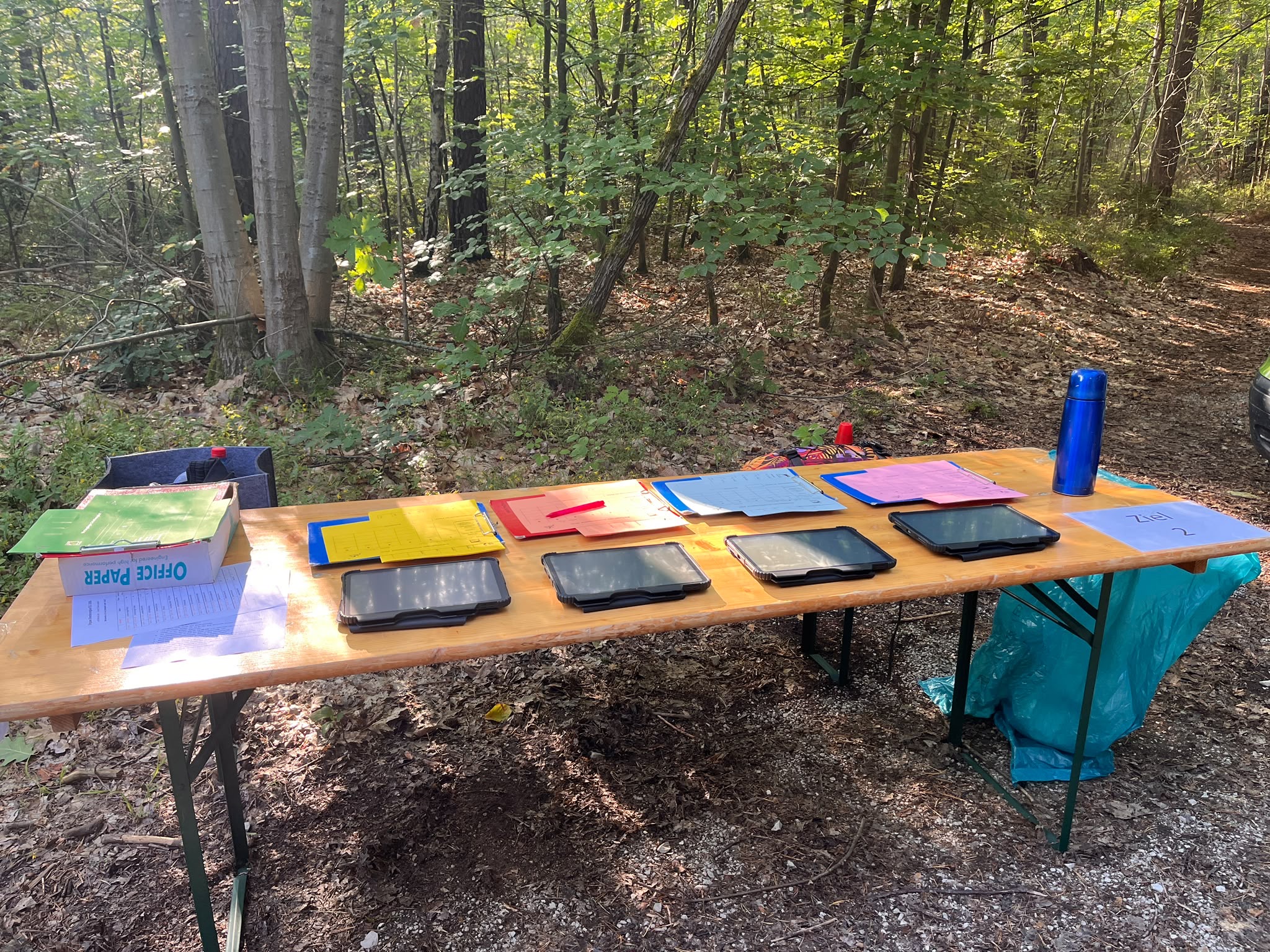Vorbereiteter Zielbereich mit farbigen Laufkarten und Tablets.